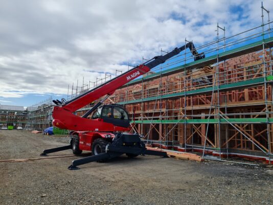 Rotating Telehandler Reaching Over Scaffolding